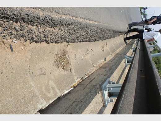 A prime example of how tar has to be layered over and over again after sinking lower because of the weight of vehicles.
